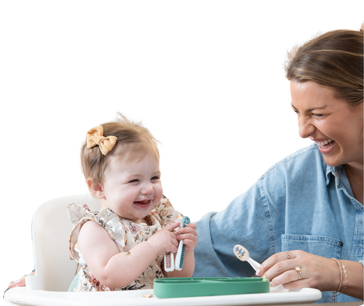 Woman feeding a baby in a high chair with a spoon and bib.