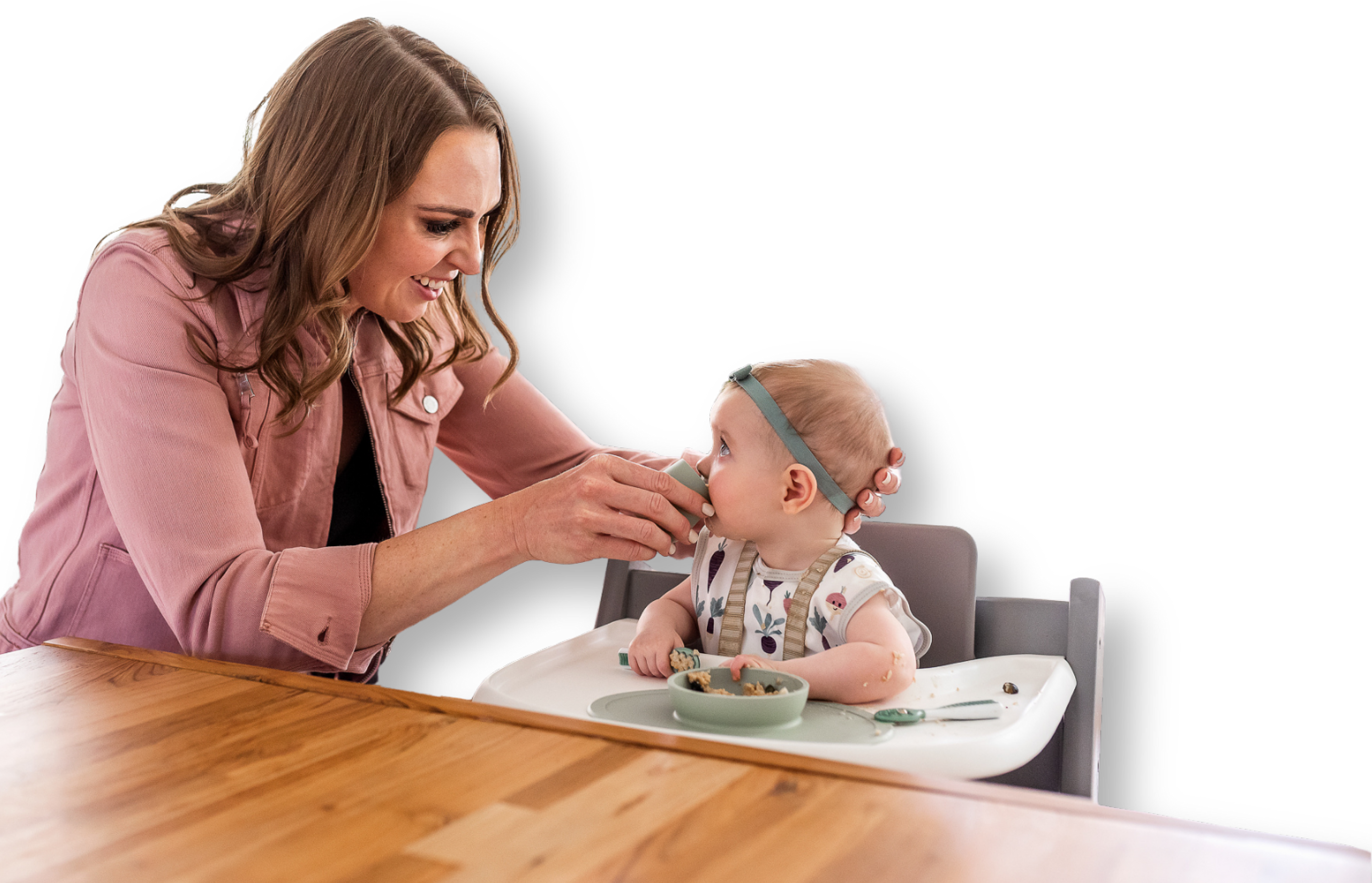 Woman feeding a baby in a high chair with a transparent background