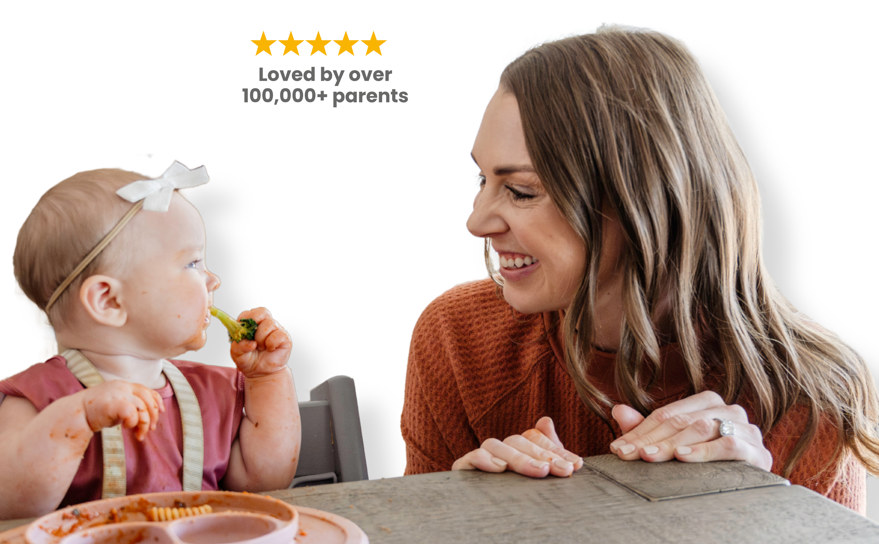 Woman with a baby eating broccoli