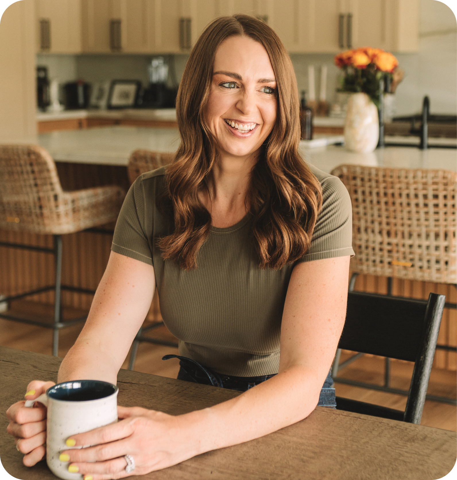 woman in green shirt, holding a coffee mug