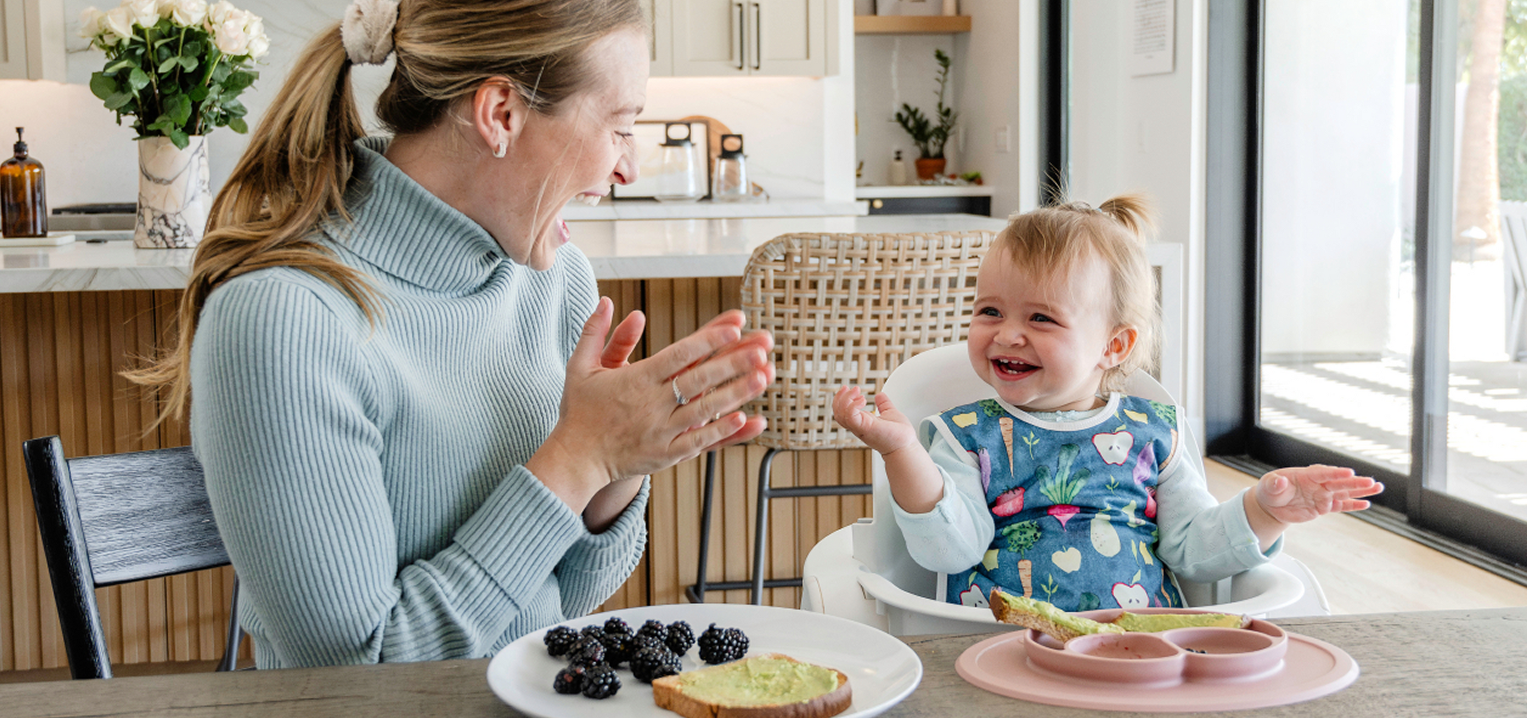 Woman and child in a kitchen setting with a plate of food